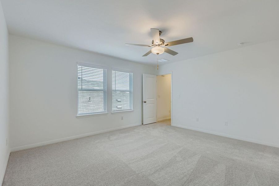 Carpeted spare room featuring baseboards and a ceiling fan Carpeted spare room featuring baseboards and a ceiling fan