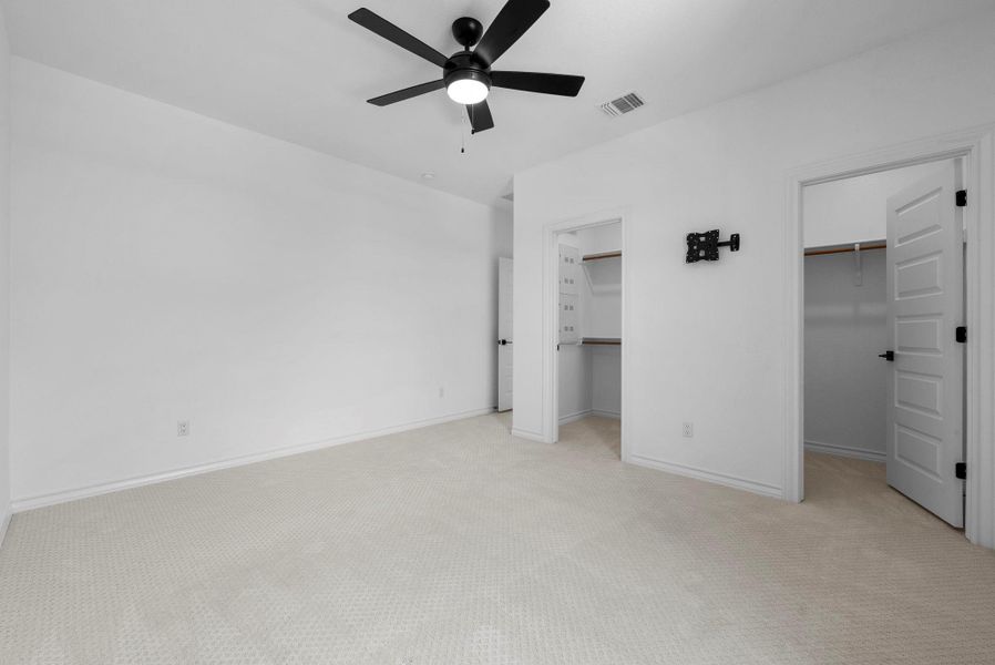Spacious bedroom with ceiling fan and walk-in closet.