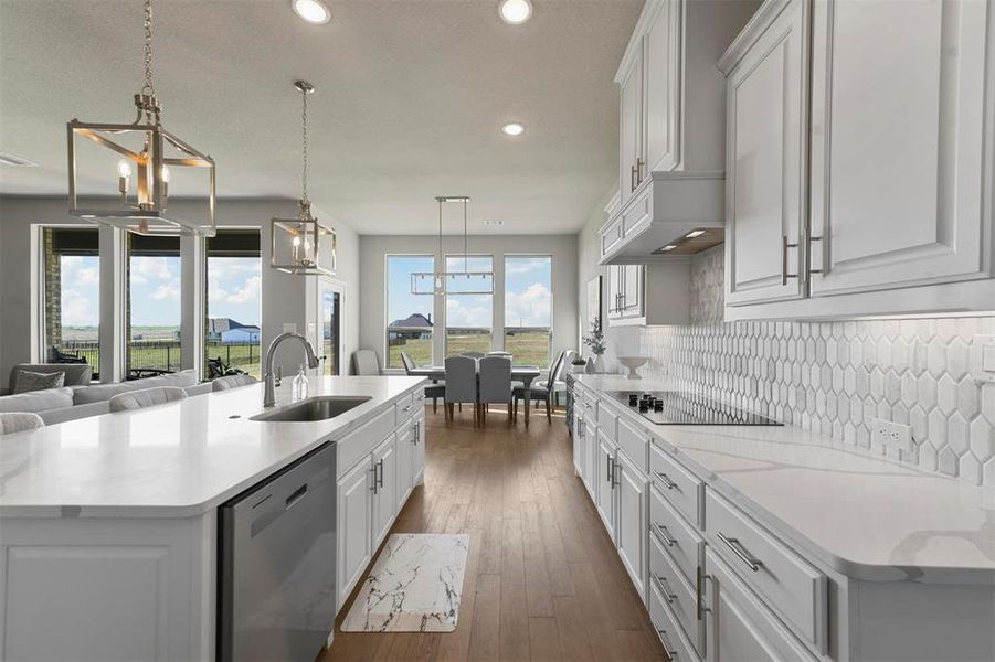 Kitchen featuring dishwasher, pendant lighting, white cabinetry, and a large island