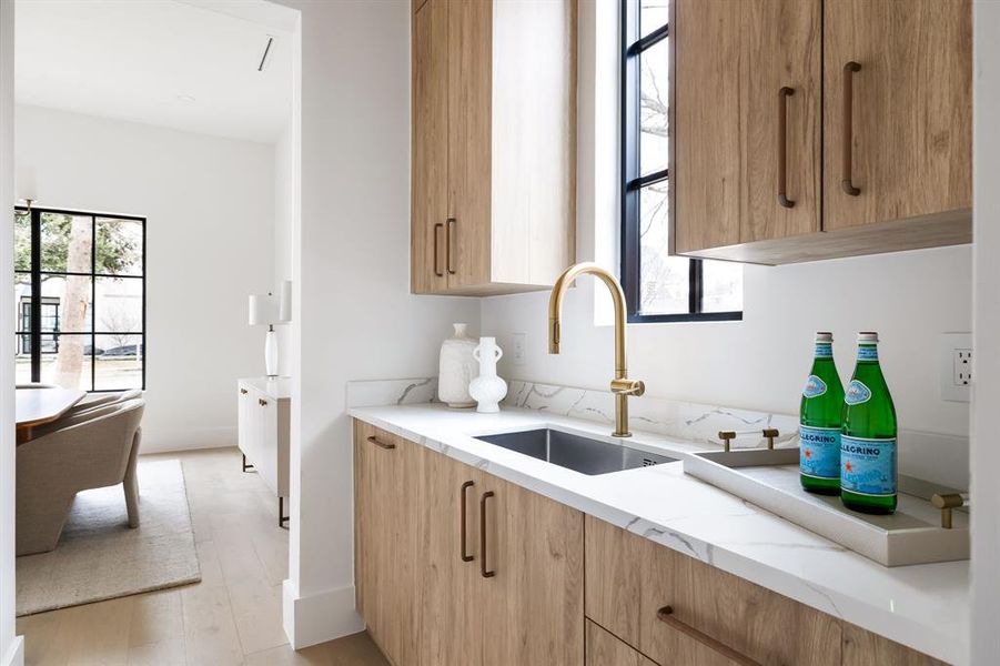 Kitchen featuring light wood-type flooring, plenty of natural light, and a sink