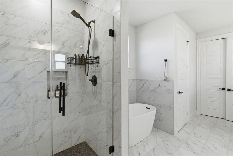 Full bathroom with a soaking tub, tile walls, a marble finish shower, marble look tiles, and wainscoting