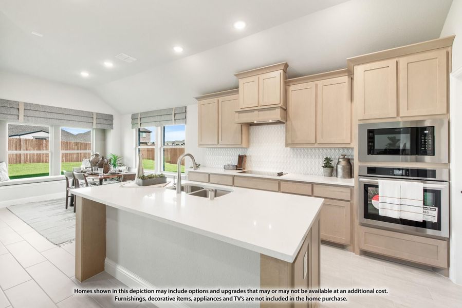Kitchen with large center island, light wood cabinets, white countertops, and stainless steel appliances