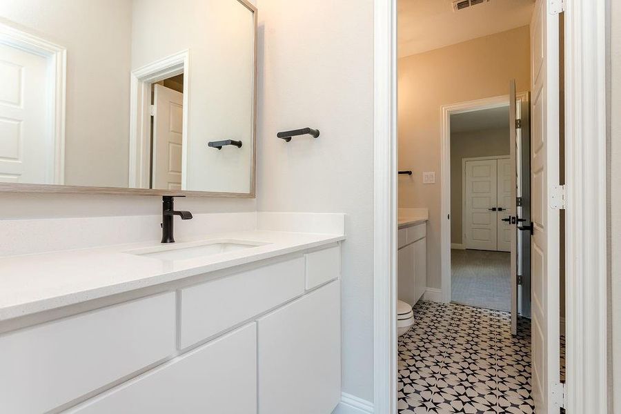 Bathroom featuring tile patterned flooring, toilet, and vanity