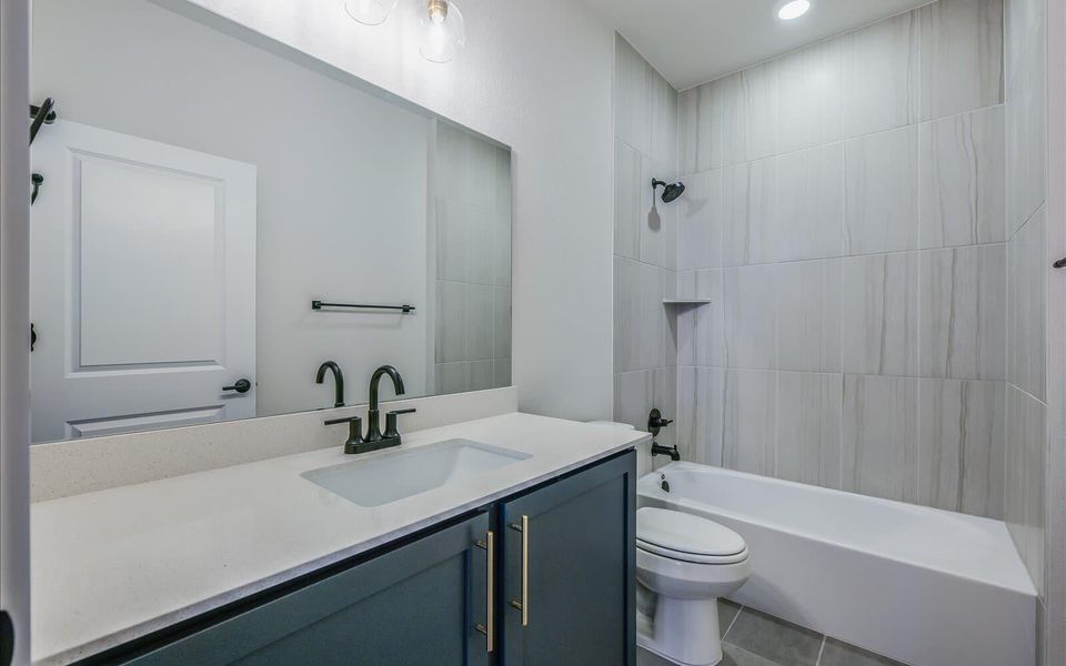 Bathroom featuring vanity, washtub / shower combination, light tile patterned floors, and recessed lighting