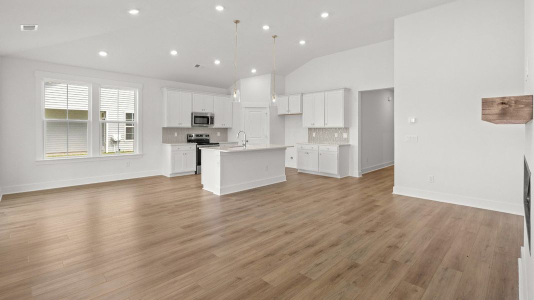 Bright living room with vaulted ceiling, open design, and seamless flow to the kitchen. Bright living room with vaulted ceiling, open design, and seamless flow to the kitchen.
