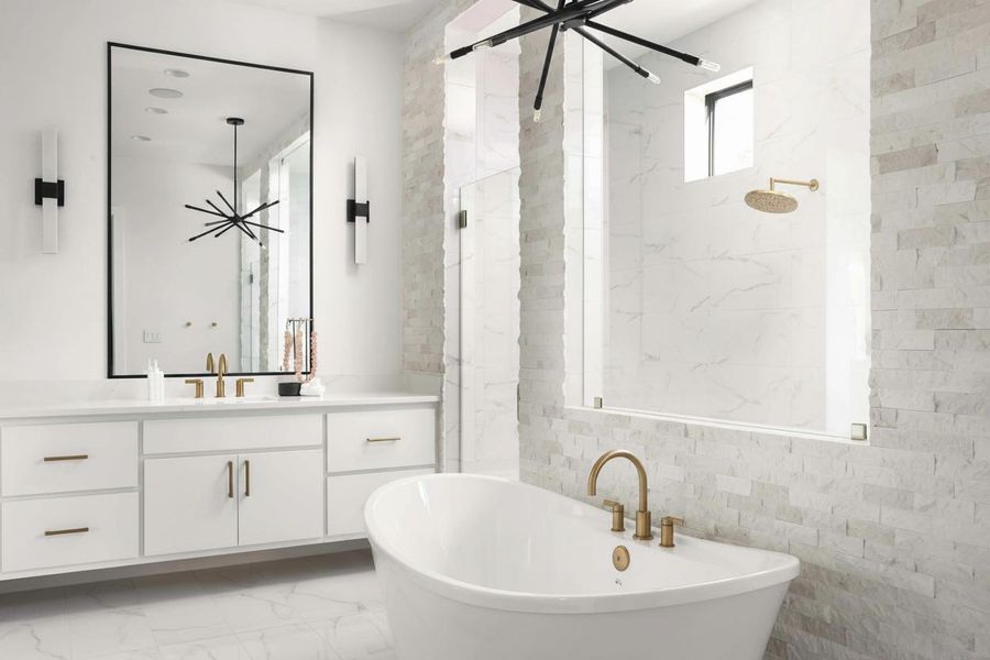 Modern bathroom featuring a freestanding soaking tub with brass fixtures