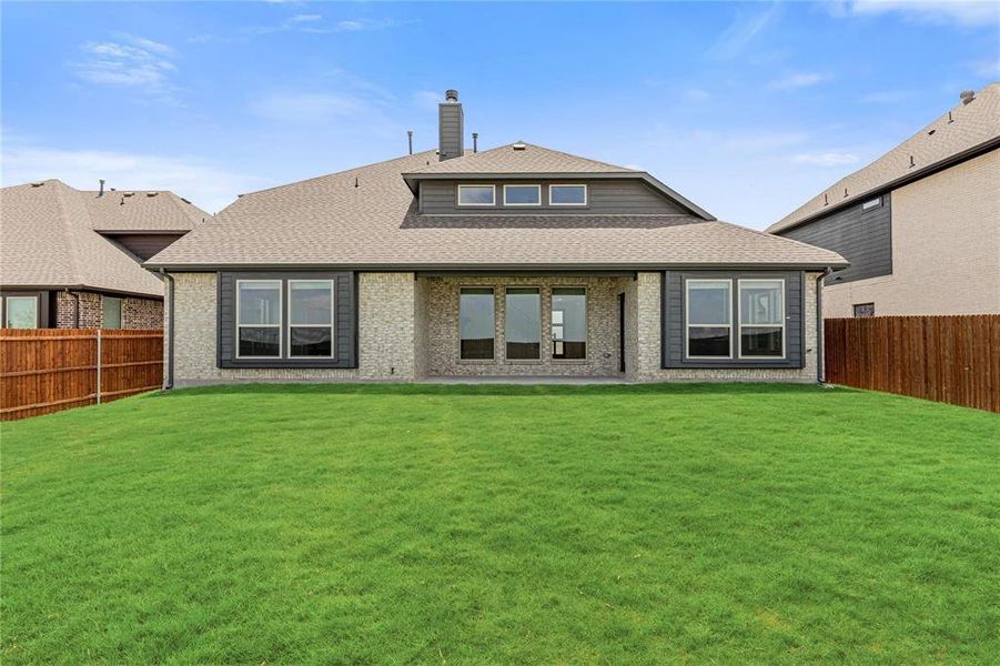 Back of the house showcasing the roof-covered patio & the detail work around the windows - note, this home also offers full gutters.