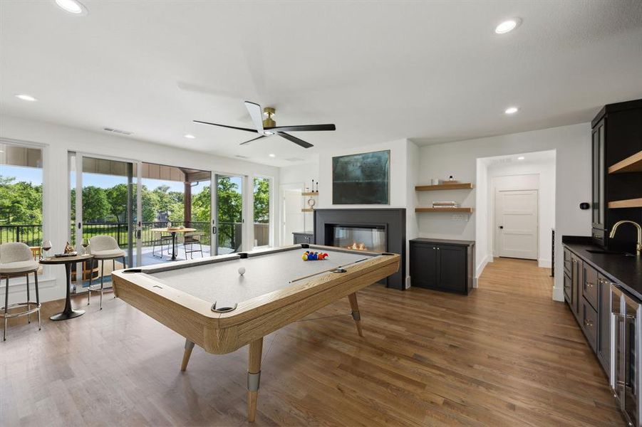 Rec room featuring pool table, wood finished floors, recessed lighting, beverage cooler, and a glass covered fireplace Rec room featuring pool table, wood finished floors, recessed lighting, beverage cooler, and a glass covered fireplace