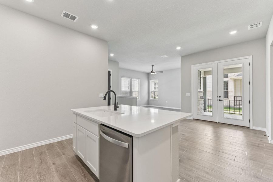 Kitchen featuring white cabinetry, dishwasher, open floor plan, light wood-style flooring, and recessed lighting