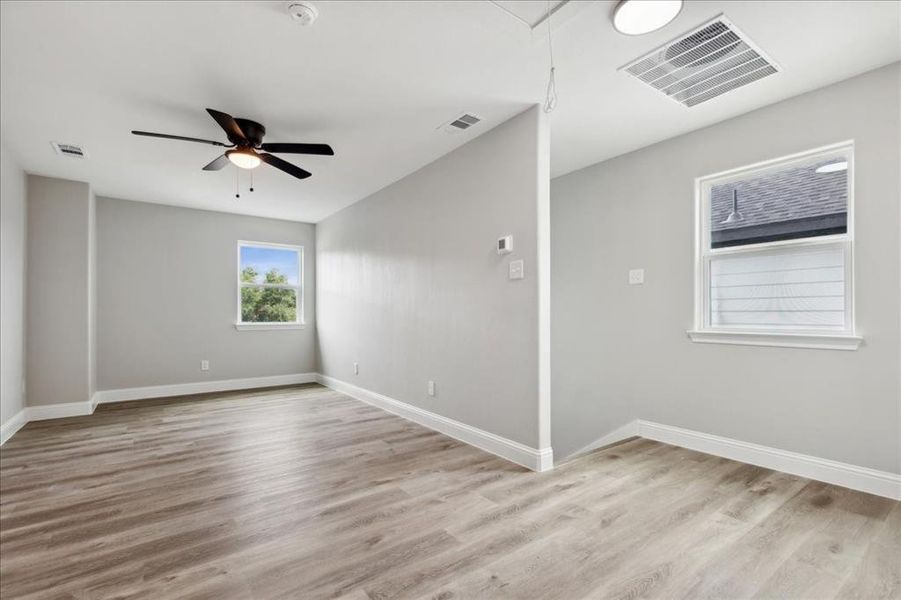 Unfurnished room featuring light wood-type flooring and ceiling fan