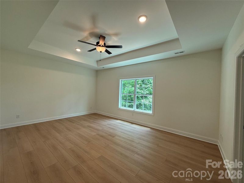 The primary bedroom is on the main floor and has a tray ceiling, double windows,...