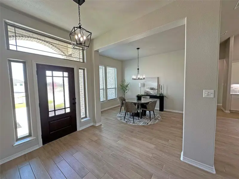 Entrance foyer featuring a chandelier and light wood-type flooring Entrance foyer featuring a chandelier and light wood-type flooring