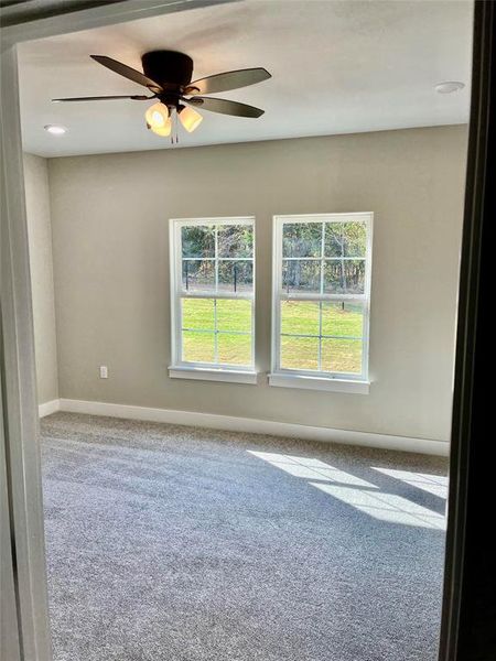 Carpeted empty room with ceiling fan