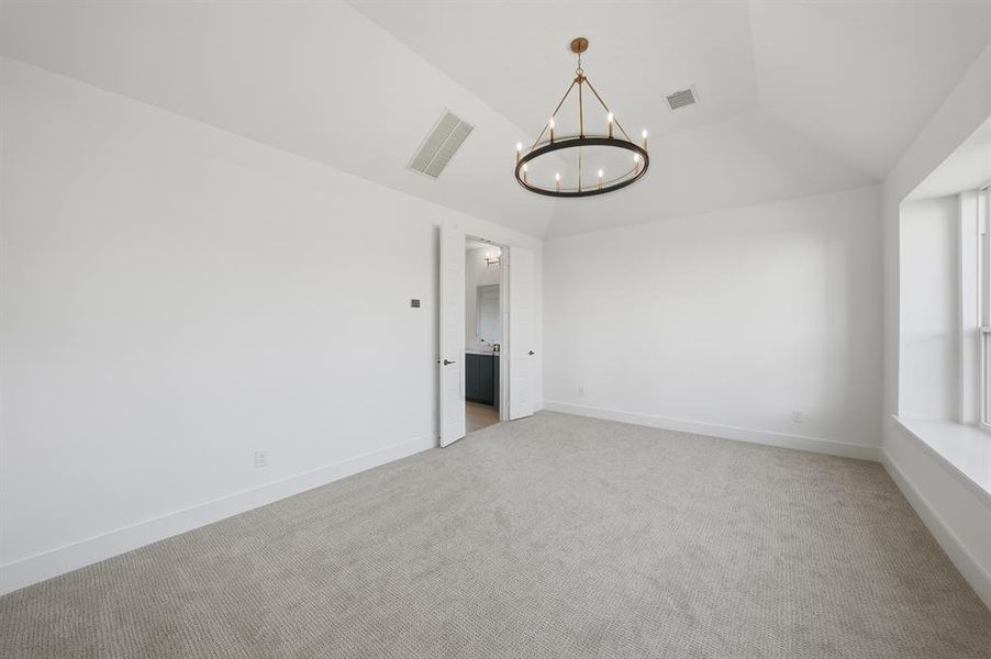 Unfurnished room with carpet flooring, a chandelier, and vaulted ceiling Unfurnished room with carpet flooring, a chandelier, and vaulted ceiling
