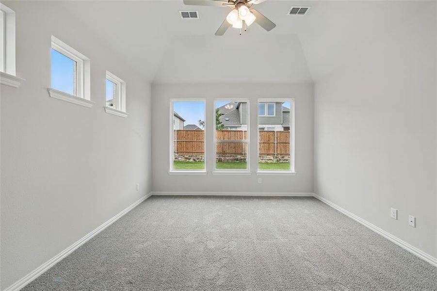 Carpeted spare room with ceiling fan, lofted ceiling, and baseboards Carpeted spare room with ceiling fan, lofted ceiling, and baseboards