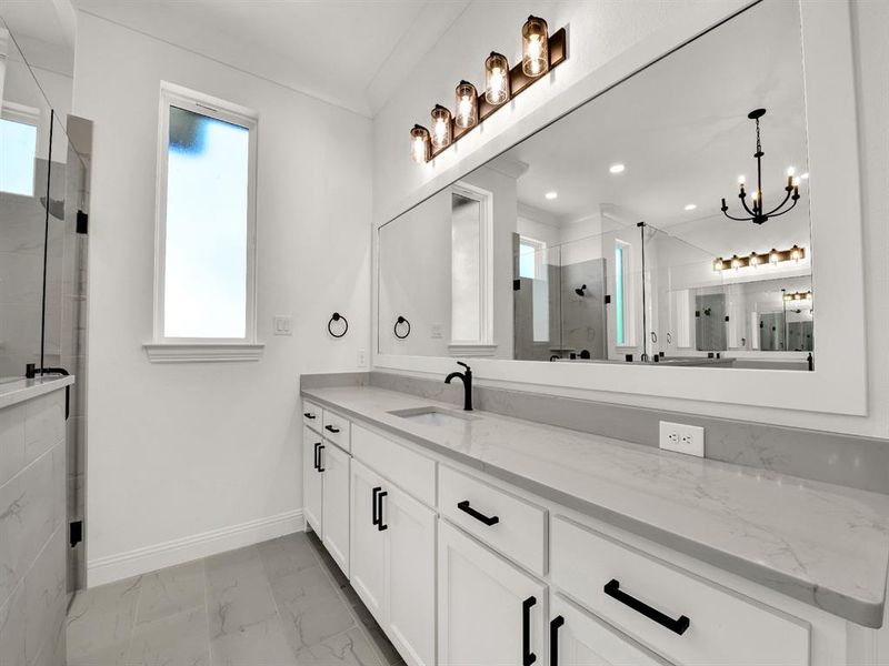 Bathroom with vanity, a chandelier, marble finish floor, a stall shower, and baseboards Bathroom with vanity, a chandelier, marble finish floor, a stall shower, and baseboards