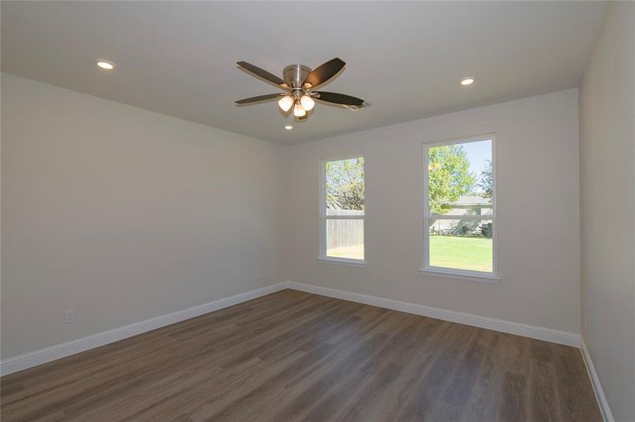 Unfurnished room with dark hardwood / wood-style flooring and ceiling fan