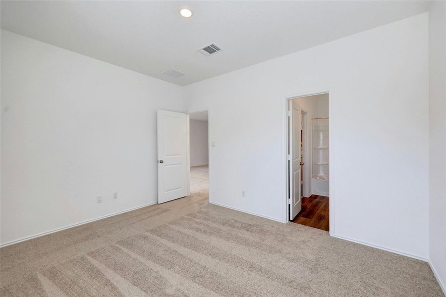 Unfurnished bedroom featuring carpet flooring, ensuite bathroom, and recessed lighting