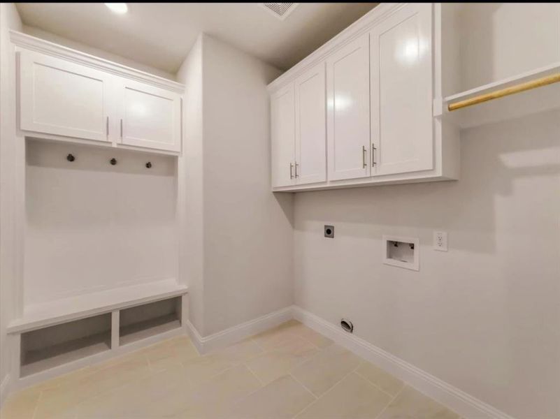 Laundry area with electric dryer hookup, hookup for a washing machine, light tile patterned floors, and cabinet space Laundry area with electric dryer hookup, hookup for a washing machine, light tile patterned floors, and cabinet space