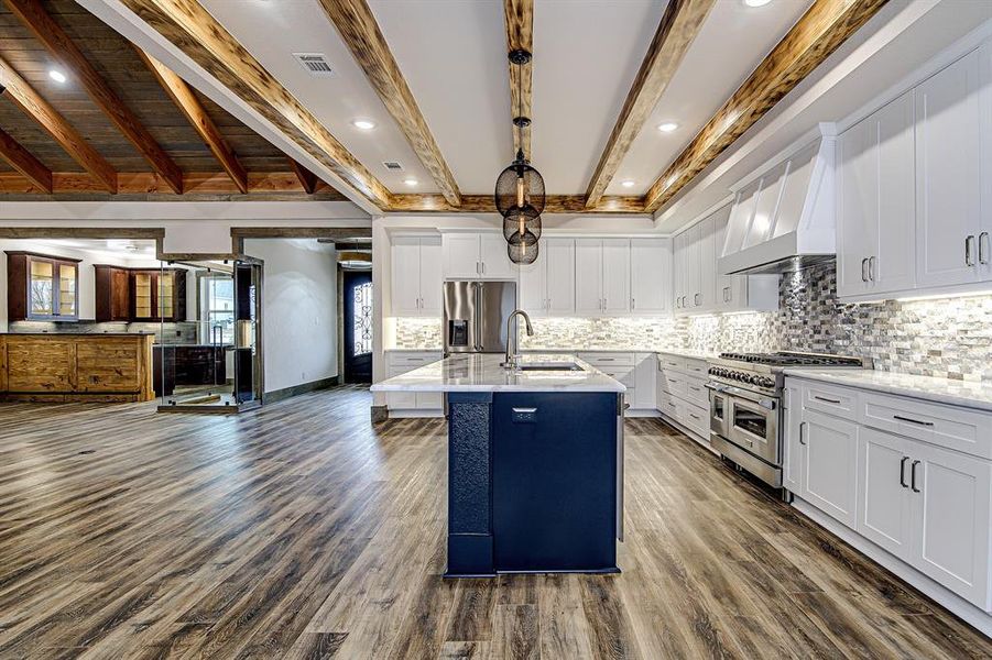 Kitchen featuring appliances with stainless steel finishes, dark wood finished floors, open floor plan, and a sink Kitchen featuring appliances with stainless steel finishes, dark wood finished floors, open floor plan, and a sink