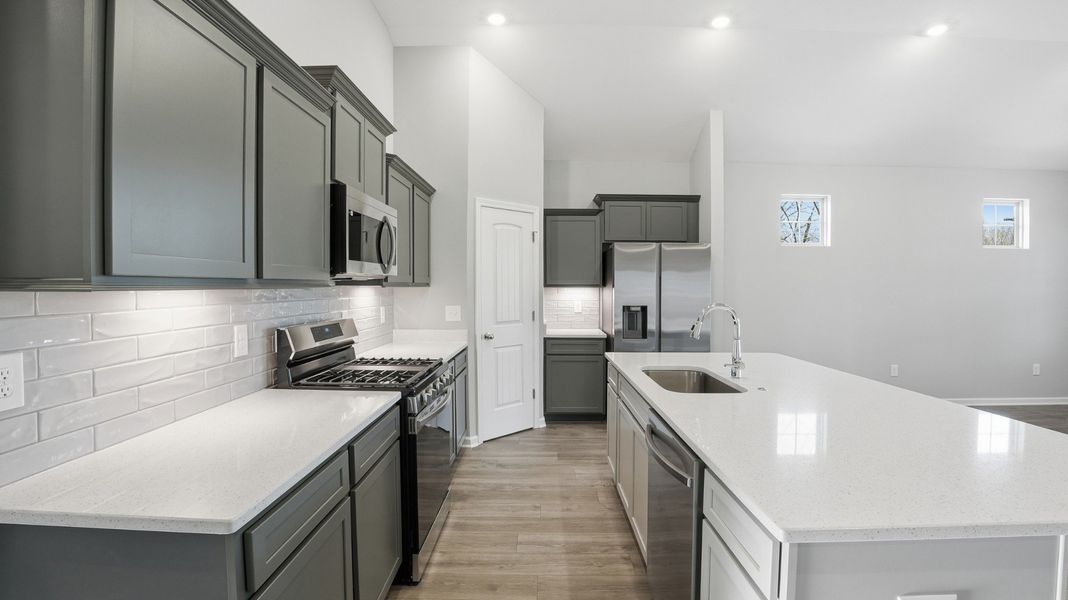 kitchen features: quartz counter tops, kitchen tile backsplash, under cab. lights, pantry, large island