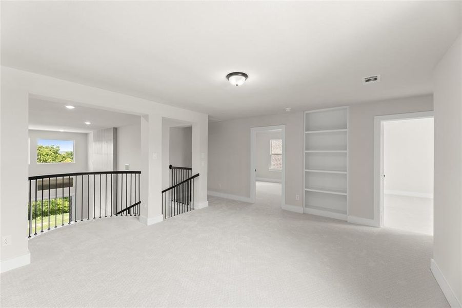 Carpeted spare room with visible vents and baseboards