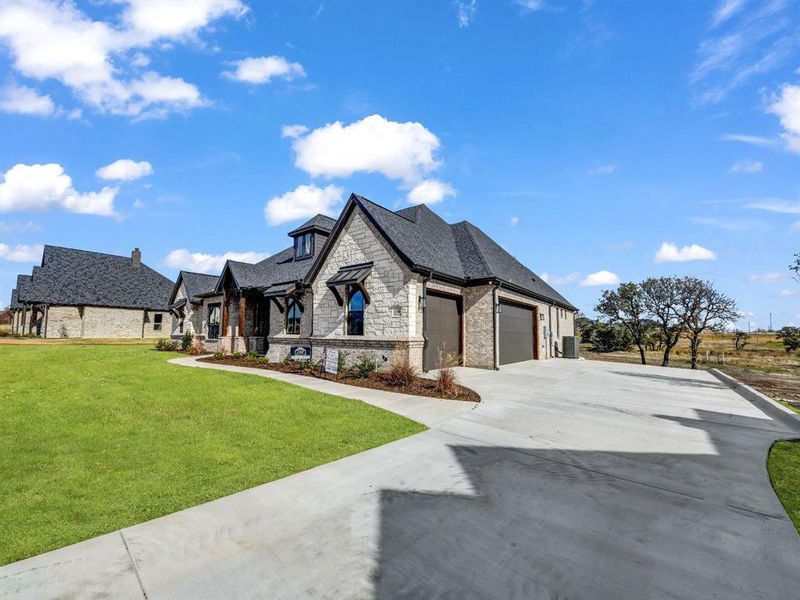 French provincial home featuring a garage and a front yard