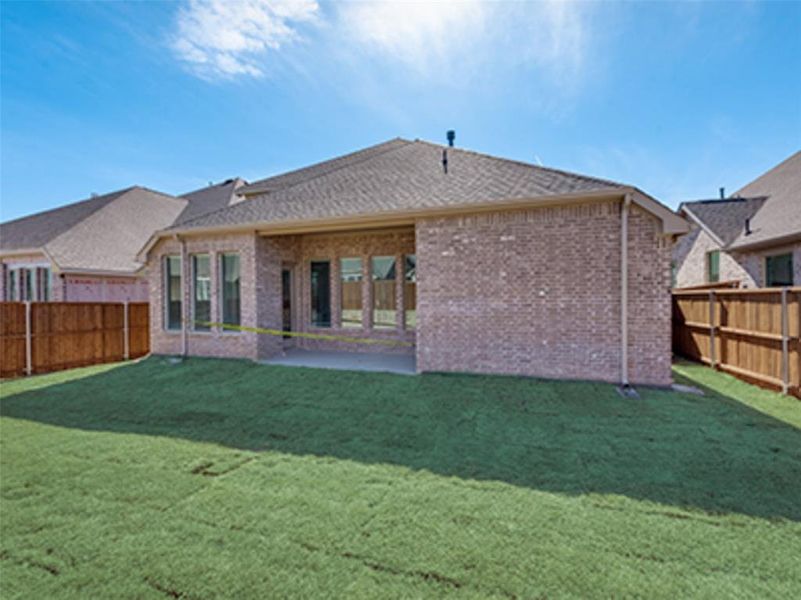 Back of property featuring a lawn and a patio area