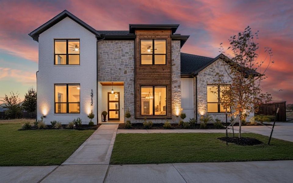 View of front of property featuring stone siding and a yard View of front of property featuring stone siding and a yard
