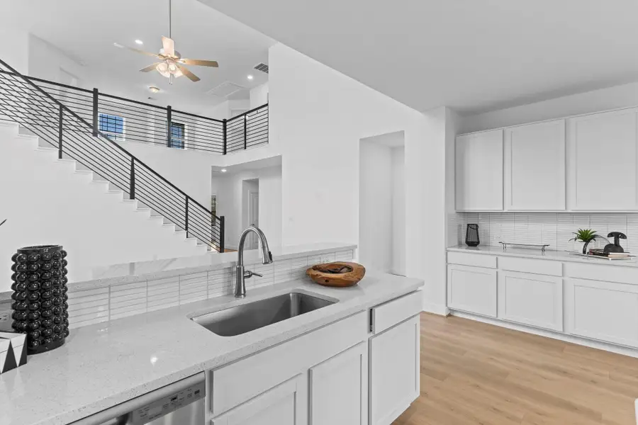 Enjoy effortless flow from the kitchen to the living space, with the island perfectly positioned for entertaining or casual dining. The woodlike tile flooring enhances the open feel and adds warmth throughout. **Image Representative of Plan Only and May Vary as Built**.