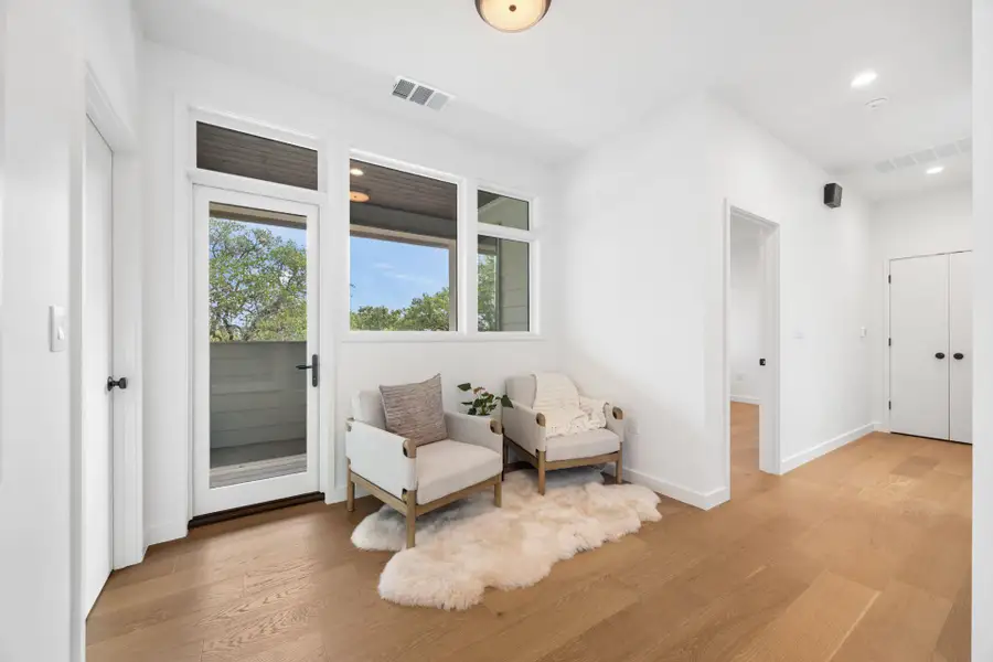 Living area with light wood finished floors and recessed lighting