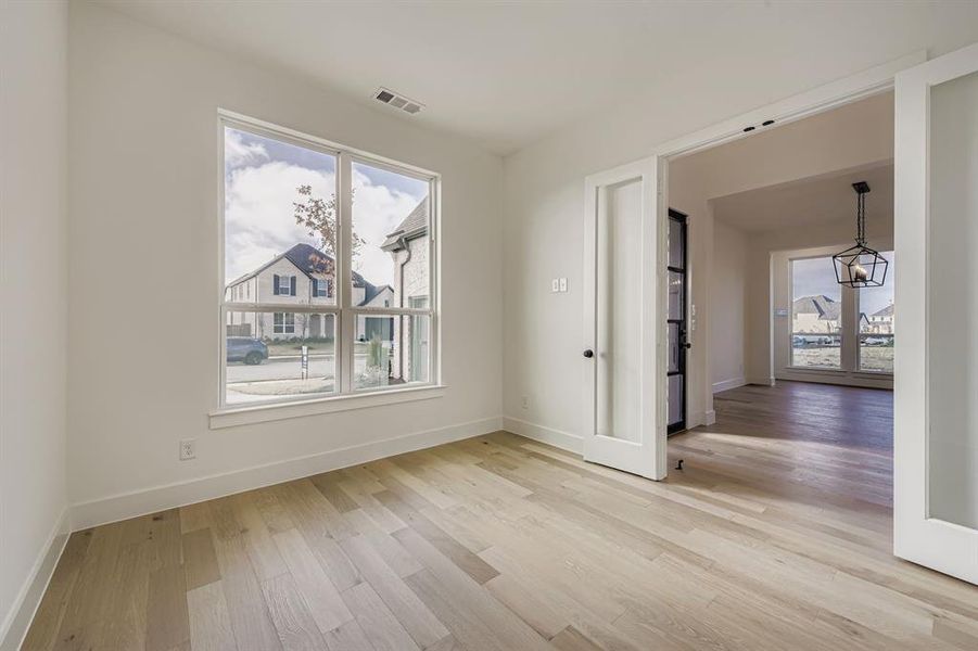 Unfurnished room featuring french doors and light wood-type flooring