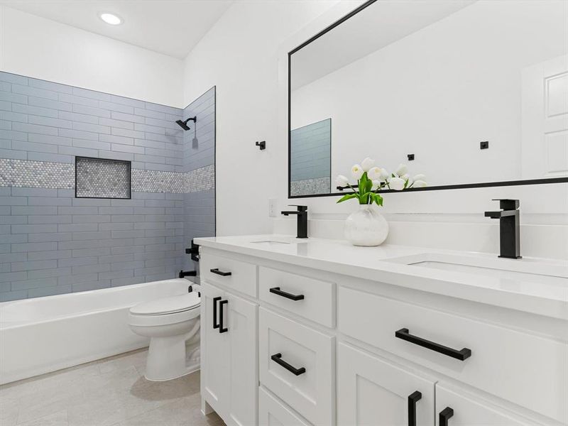 Bathroom with tub / shower combination, double vanity, and light tile patterned floors