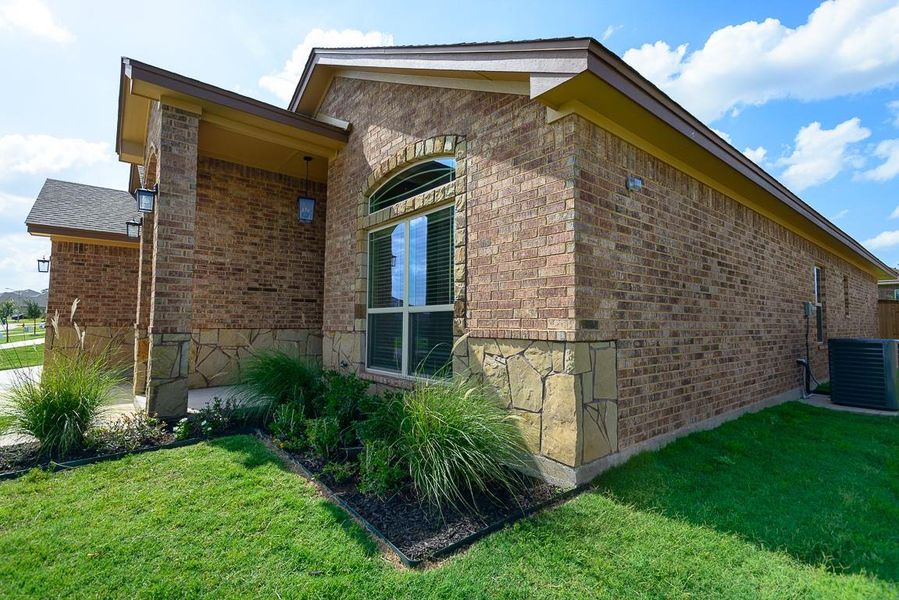 View of side of home with brick siding and a lawn View of side of home with brick siding and a lawn