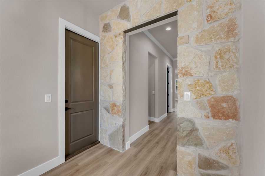 Corridor with light wood finished floors and ornamental molding