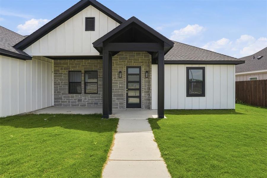 Contemporary exterior featuring white board-and-batten siding and grey stone accents