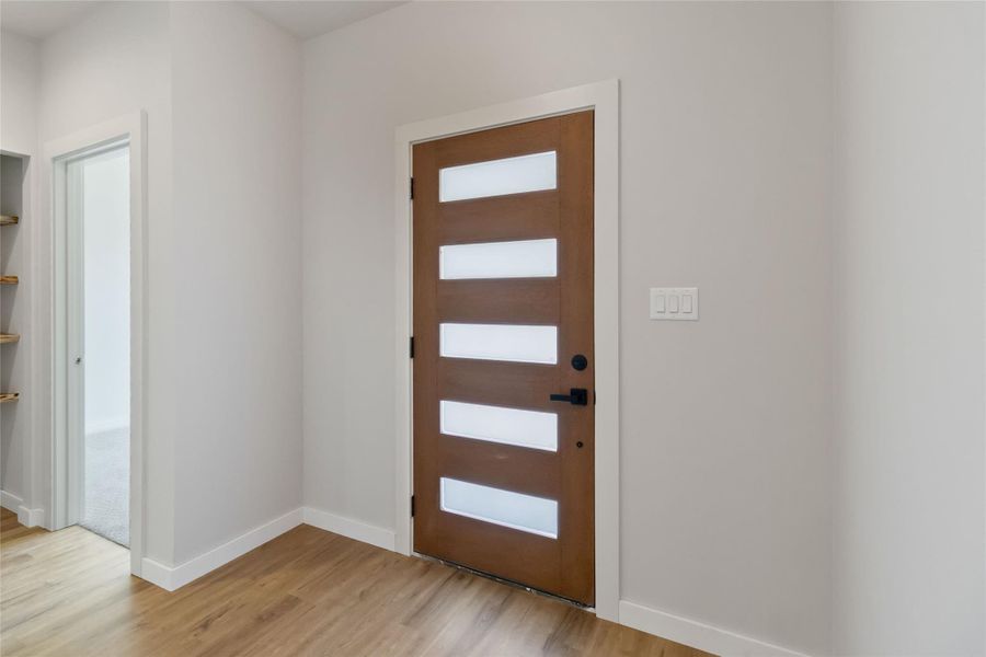 Entryway with light wood finished floors and baseboards