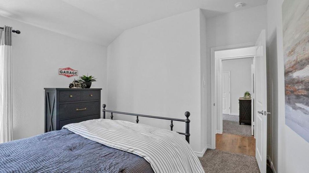 Carpeted bedroom featuring lofted ceiling and baseboards