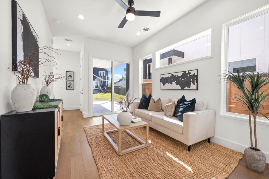 Living room with light wood-type flooring and a ceiling fan