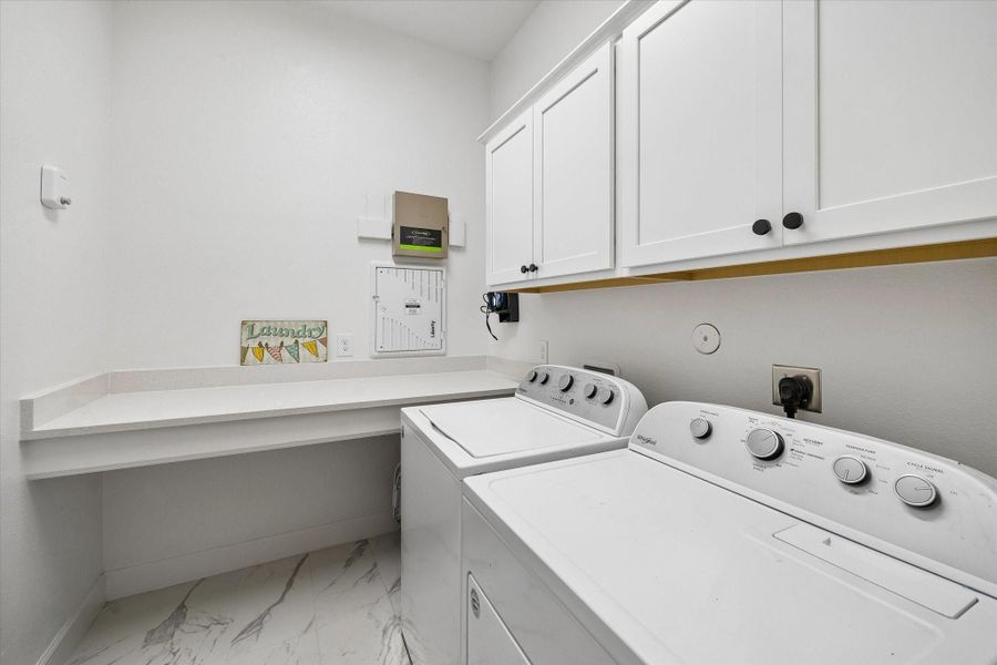 Functional utility room complete with extensive cabinetry, generous workspace, and convenient in-home laundry accommodations. Functional utility room complete with extensive cabinetry, generous workspace, and convenient in-home laundry accommodations.