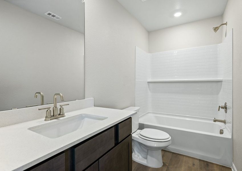 The secondary bathroom has a vanity space and a shower-tub combo.