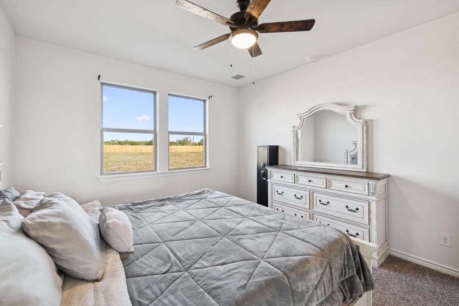 Carpeted bedroom with ceiling fan and baseboards Carpeted bedroom with ceiling fan and baseboards