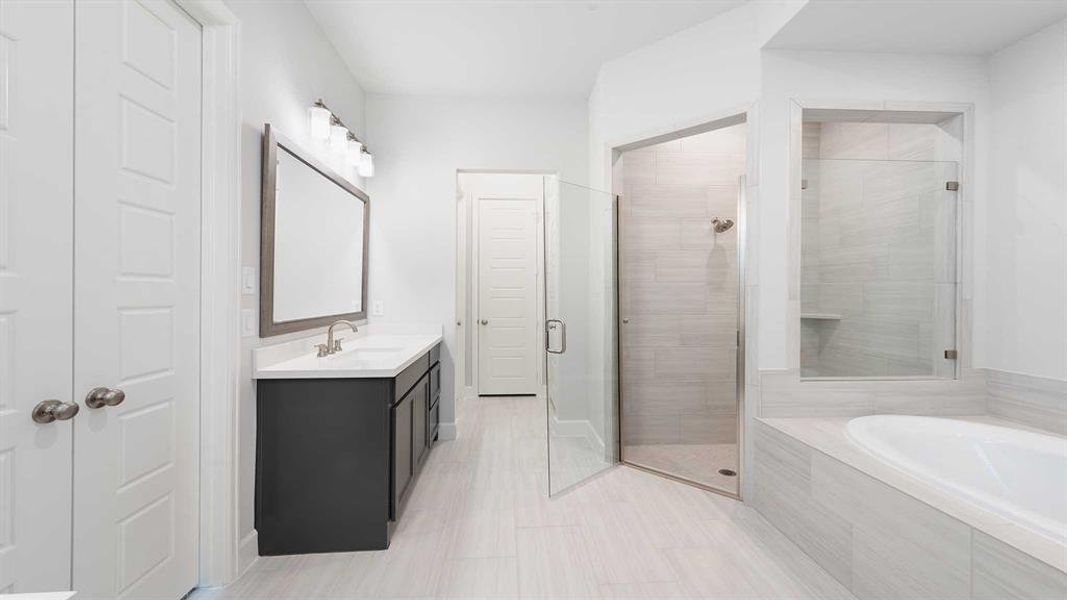 Bathroom with tile patterned flooring, vanity, and plus walk in shower