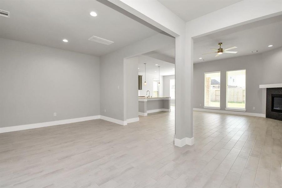 An inviting dining space seamlessly woven into the open concept, connecting the family room and kitchen. Revel in the stunning floors, and a soothing paint palette, – a perfect setting for shared meals and cherished moments. Sample photo of completed home with similar floor plan. Actual colors and selections may vary.