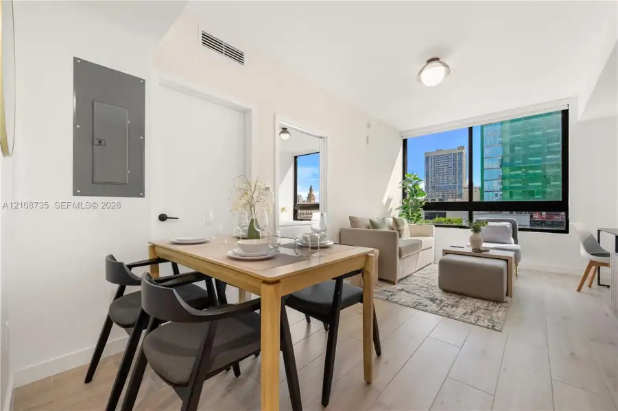 Floor-to-ceiling windows featuring urban scenery, wood-finish flooring, and recessed ceiling lighting Floor-to-ceiling windows featuring urban scenery, wood-finish flooring, and recessed ceiling lighting