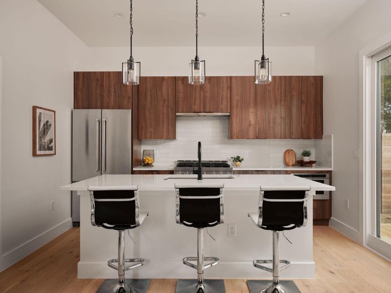 Kitchen with a center island with sink, tasteful backsplash, hanging light fixtures, modern cabinets, and high end fridge Kitchen with a center island with sink, tasteful backsplash, hanging light fixtures, modern cabinets, and high end fridge