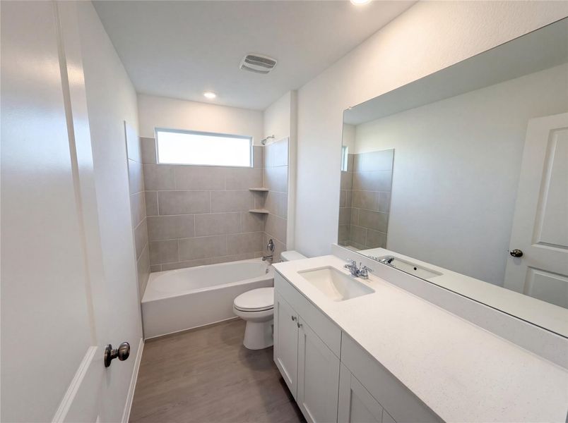 Full bathroom featuring vanity,  shower combination, and dark wood-style floors