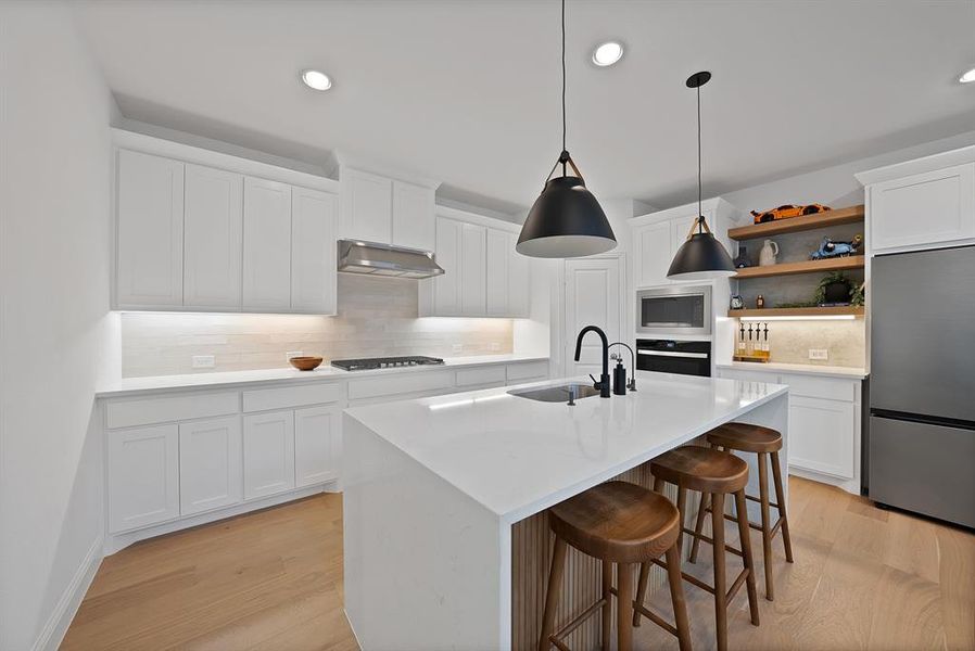 Contemporary kitchen featuring white cabinetry and light wood-finish flooring