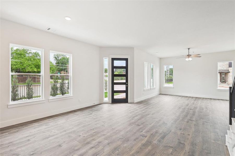 Unfurnished living room with ceiling fan and light wood-type flooring