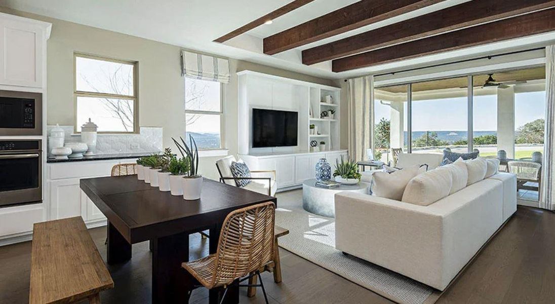 Living area with beamed ceiling, plenty of natural light, dark wood-style floors, and ceiling fan Living area with beamed ceiling, plenty of natural light, dark wood-style floors, and ceiling fan